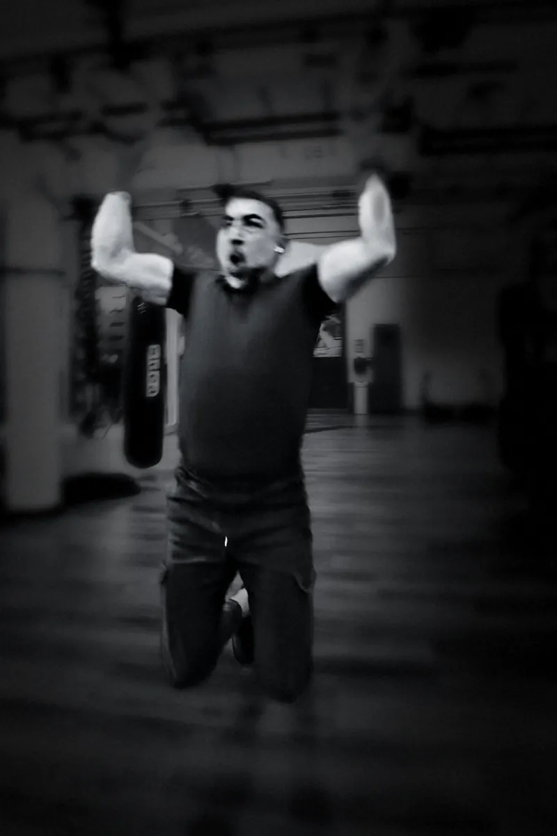 Houman Farzian finishing a pull on the rings, black and white