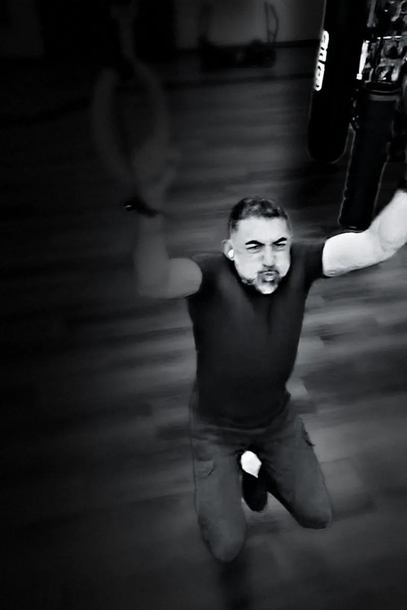 Houman Farzian pulling on gymnastic rings, black and white