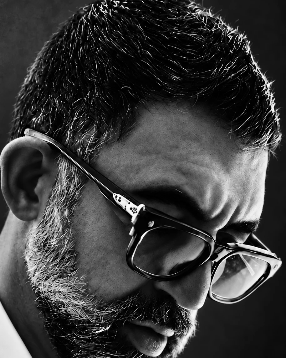Houman Farzian in glasses, looking down in thought, black and white